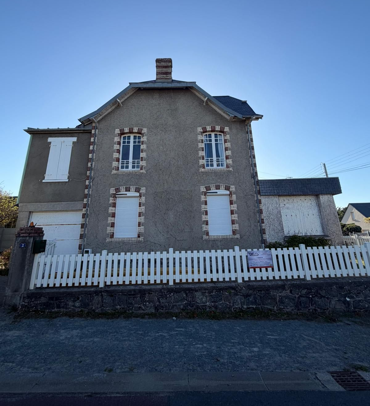 Maison en crépi gris avant ravalement.