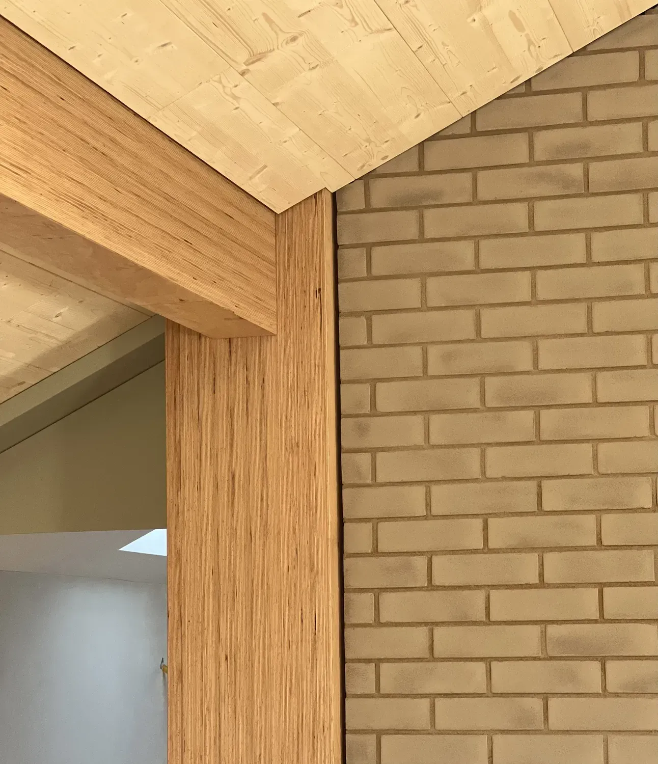 Ein Holzbalken liegt neben einer Ziegelwand.