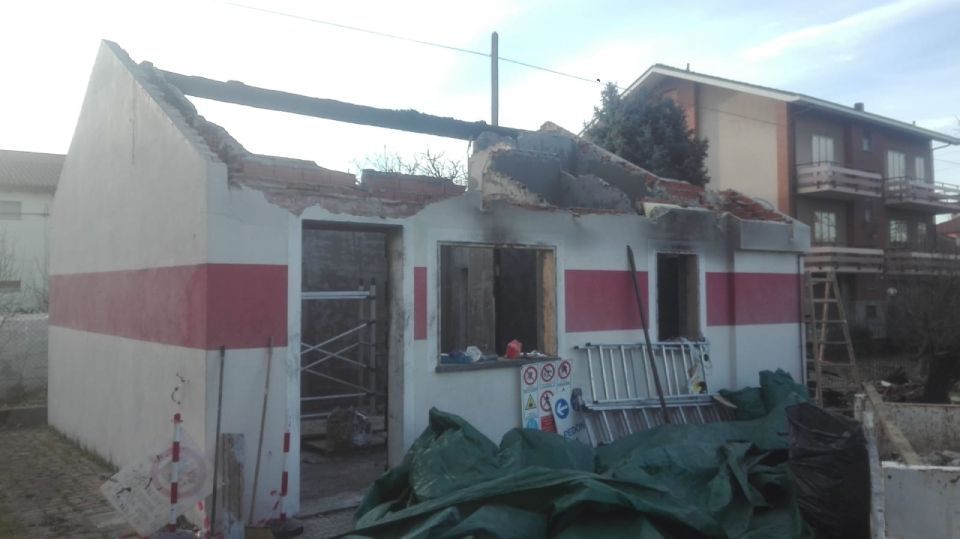 Edificio parzialmente demolito, dettaglio della striscia rossa, materiali da costruzione sparsi.