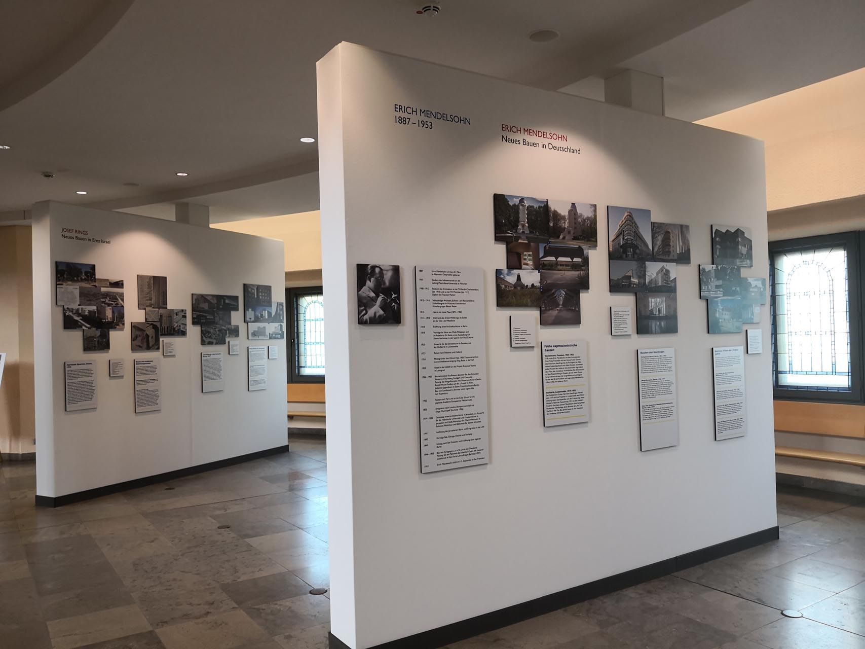 Eine Reihe von Bildern hängt an einer weißen Wand in einem Raum.