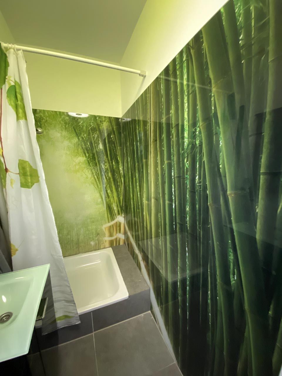 Ein Badezimmer mit einem Bild von Bambus an der Wand.