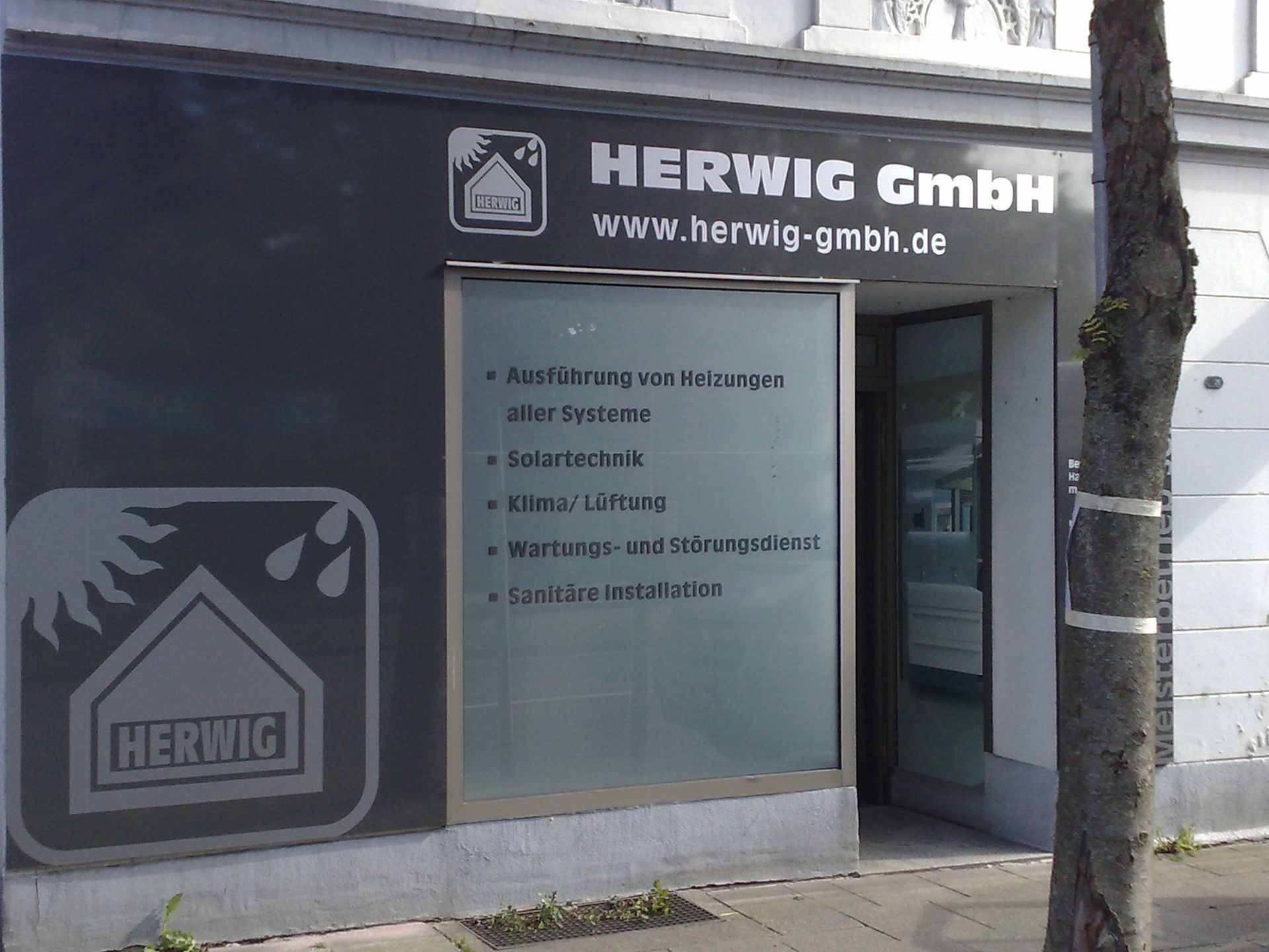 Ein Schild, das Herwig GmbH mit Glasbeschriftungen