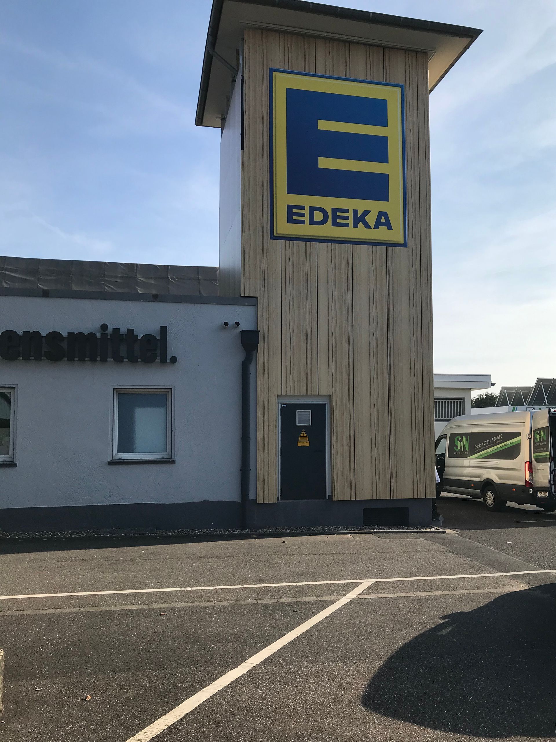 Ein Gebäude mit einem großen Werbeanlage Edeka-Logo darauf