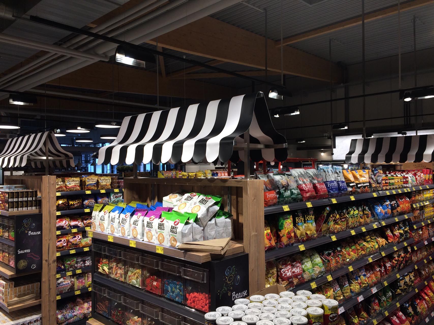 Ein Lebensmittelgeschäft mit einem schwarz-weiß gestreiften Zelt über den Regalen.