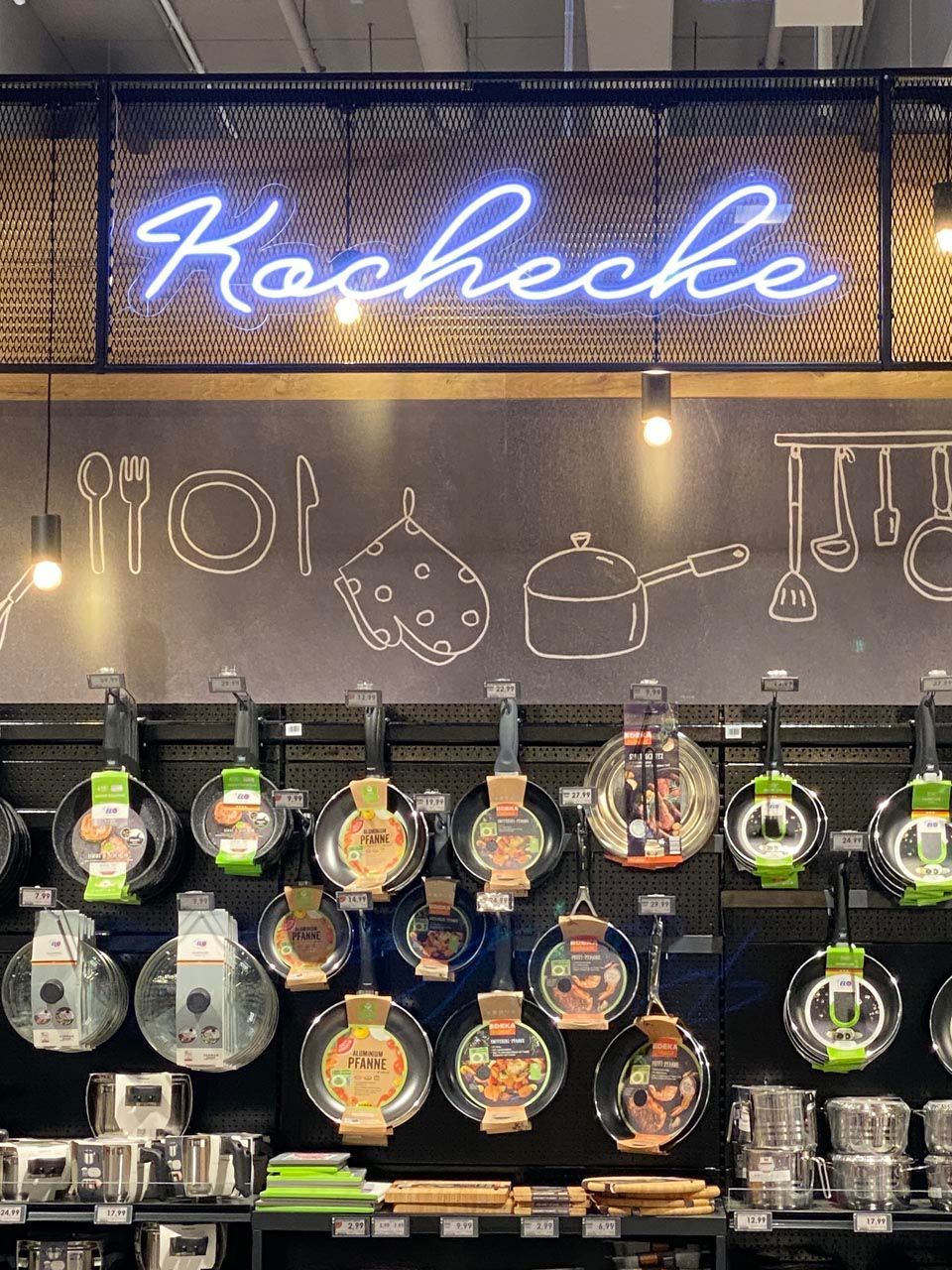 Objektgestaltung von Pfannen in einem Einkaufszentrum mit der Beschriftung Kochen.