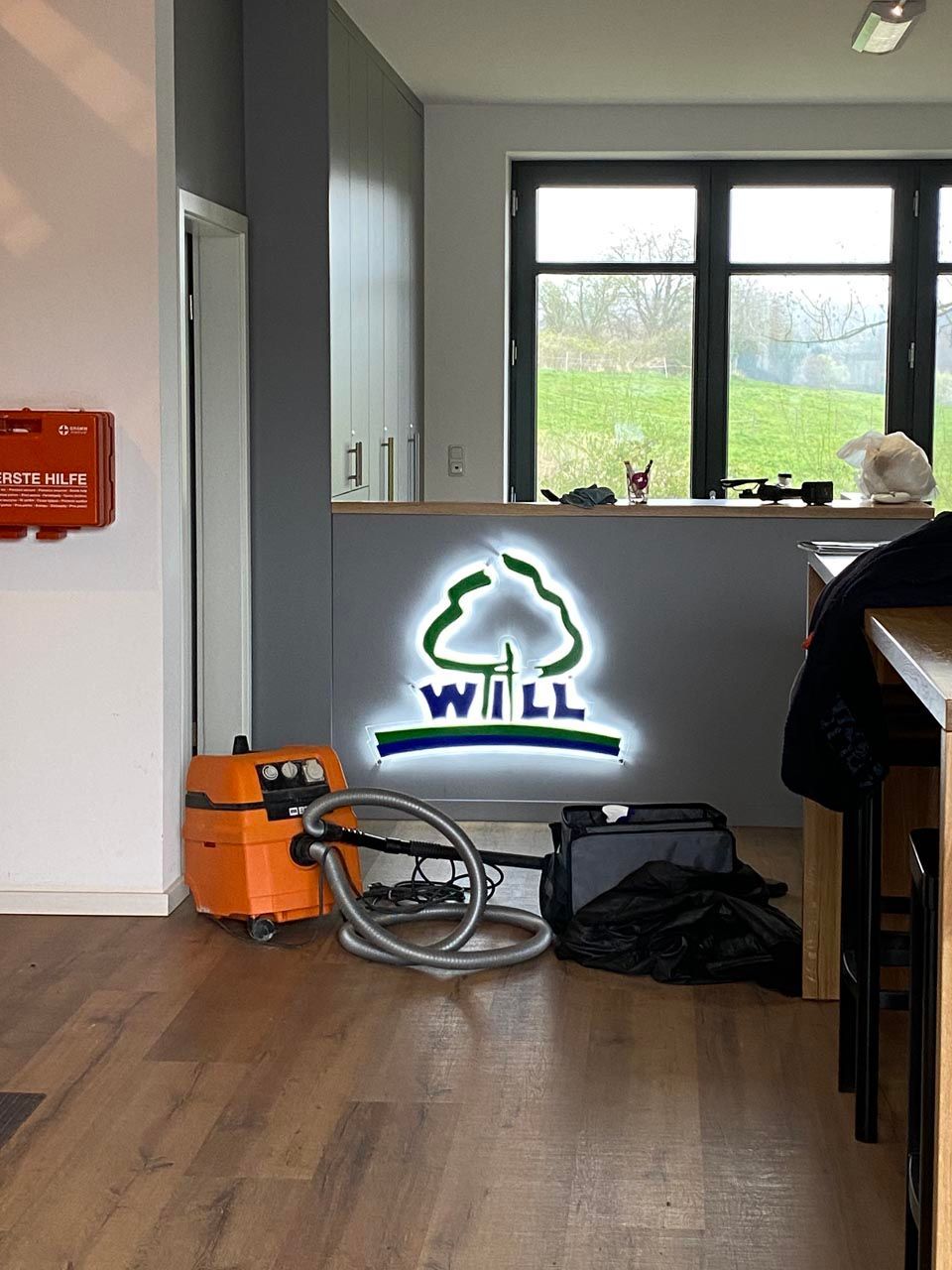 Ein Raum mit einem Logo für will und einem Staubsauger.