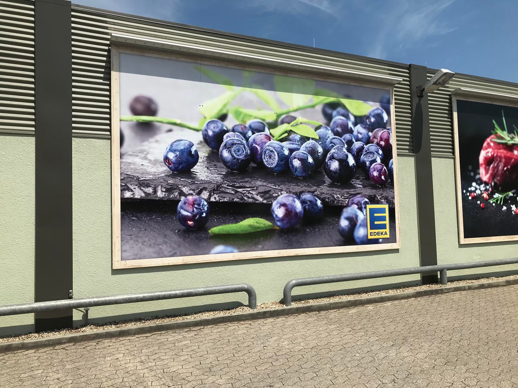 Beleuchtete Schildanlage mit einem Bild von Blaubeeren aus EDEKA.