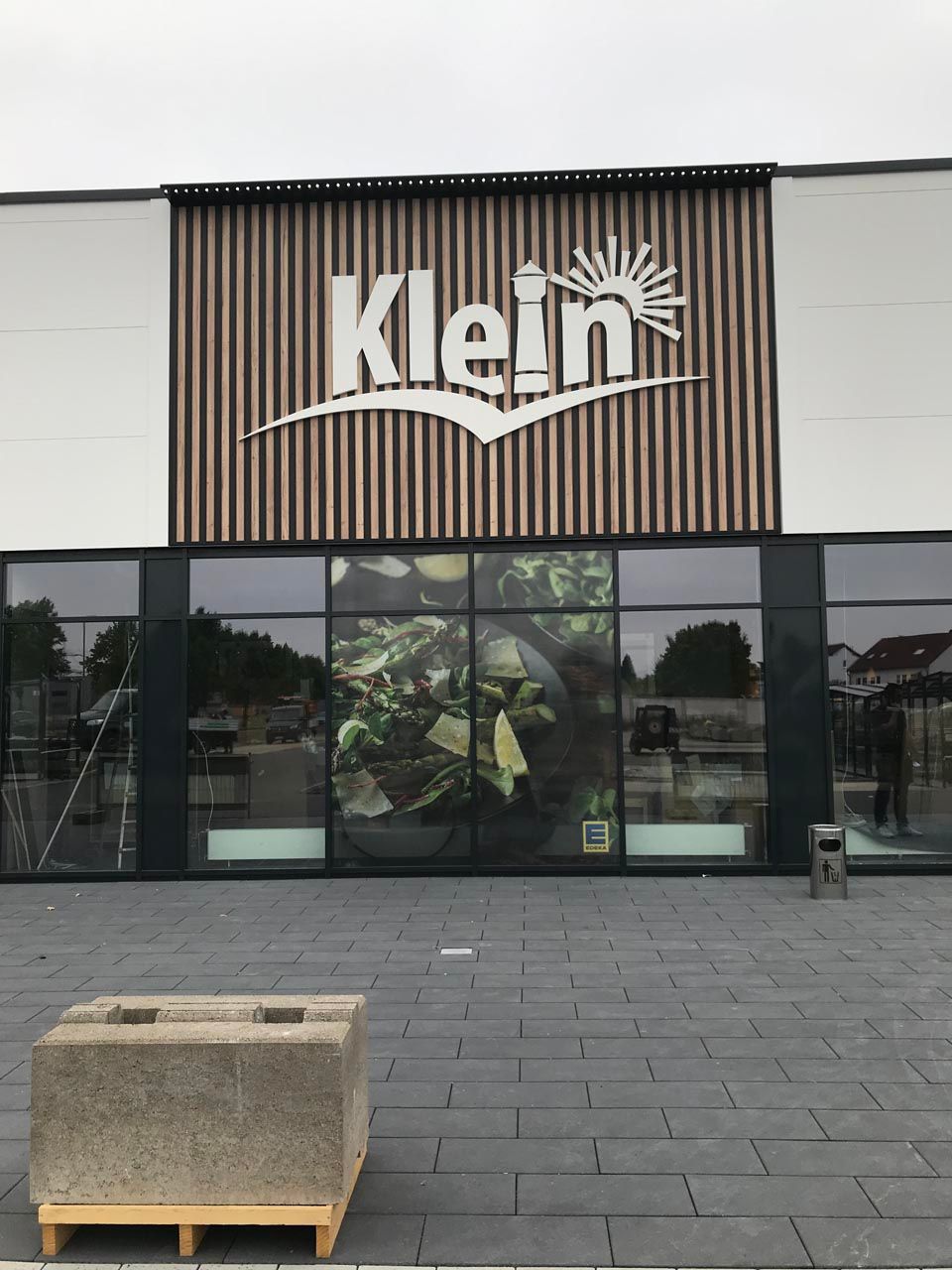 Eine beleuchtete Schildanlage mit der Schriftzug Klein über der Vorgang vom Edeka