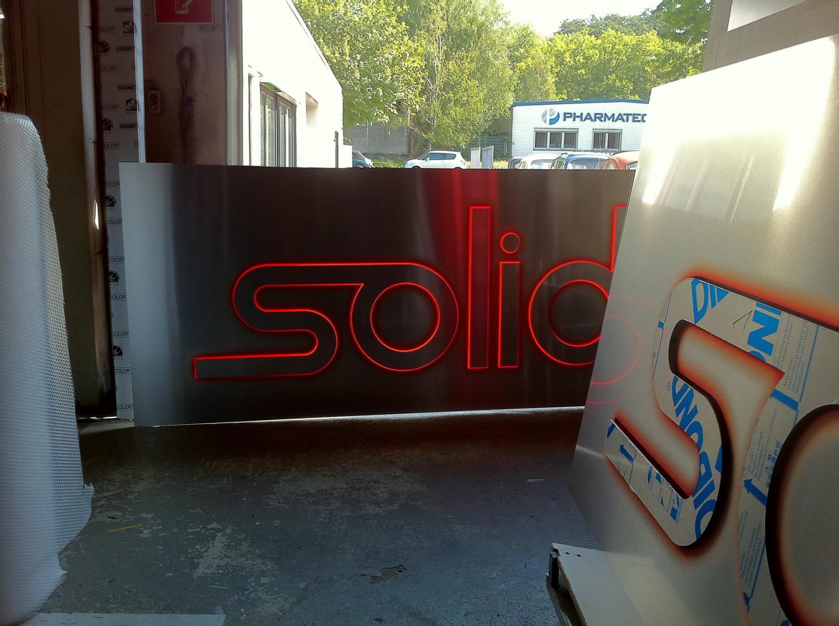 Beleuchtete Schildanlagen mit der Schriftzug Solid