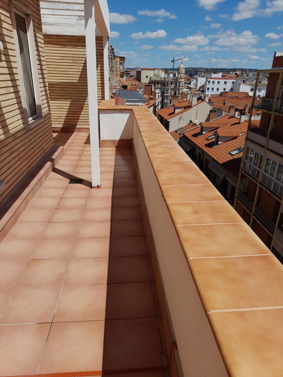 Vista aérea del techo de un gran edificio industrial gris, con ventilaciones, tuberías y características mecánicas.