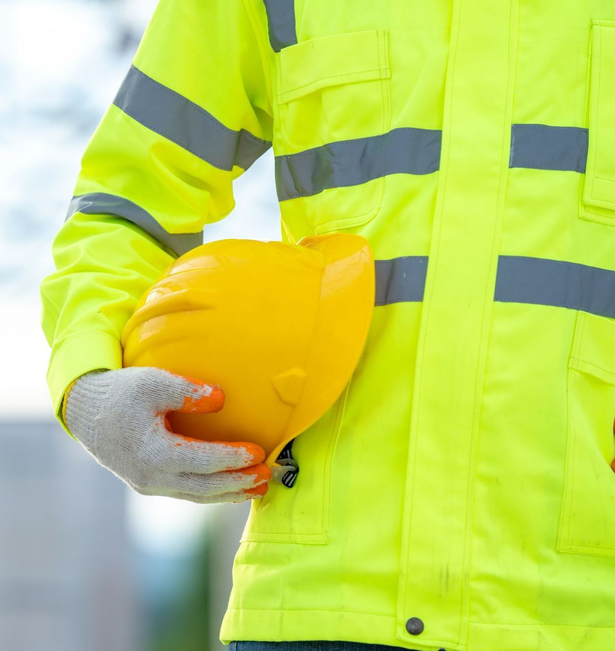 Professionnel avec veste jaune portant un casque jaune