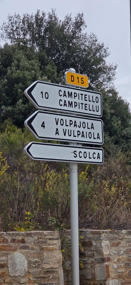 Un panneau routier sur un poteau indiquant les distances jusqu'à Campitello, Volpajola et Scolca sur la route D15.