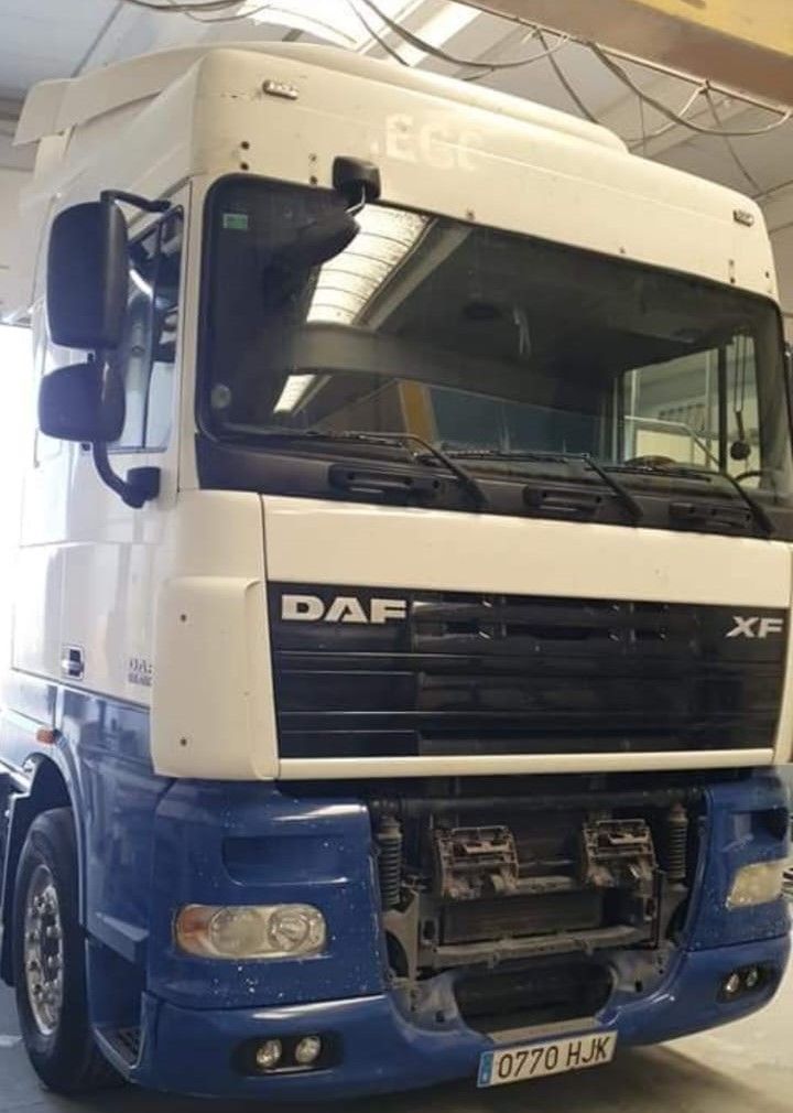 Un camión DAF azul y blanco está estacionado en un garaje.