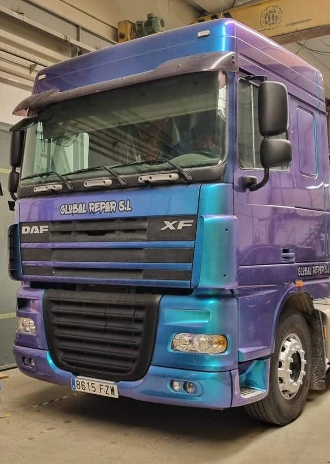 Un camión DAF morado está estacionado en un garaje.