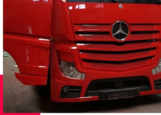 Un camión Mercedes rojo está estacionado en un garaje.
