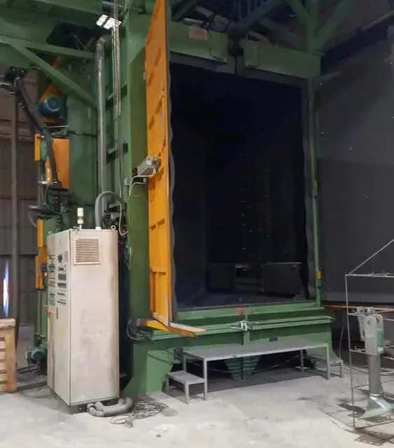 Una gran máquina verde con una puerta amarilla en una fábrica.