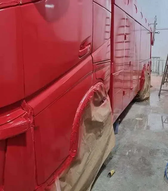Se está pintando una furgoneta roja en un garaje.