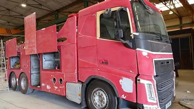 Se está pintando un camión rojo en un garaje.