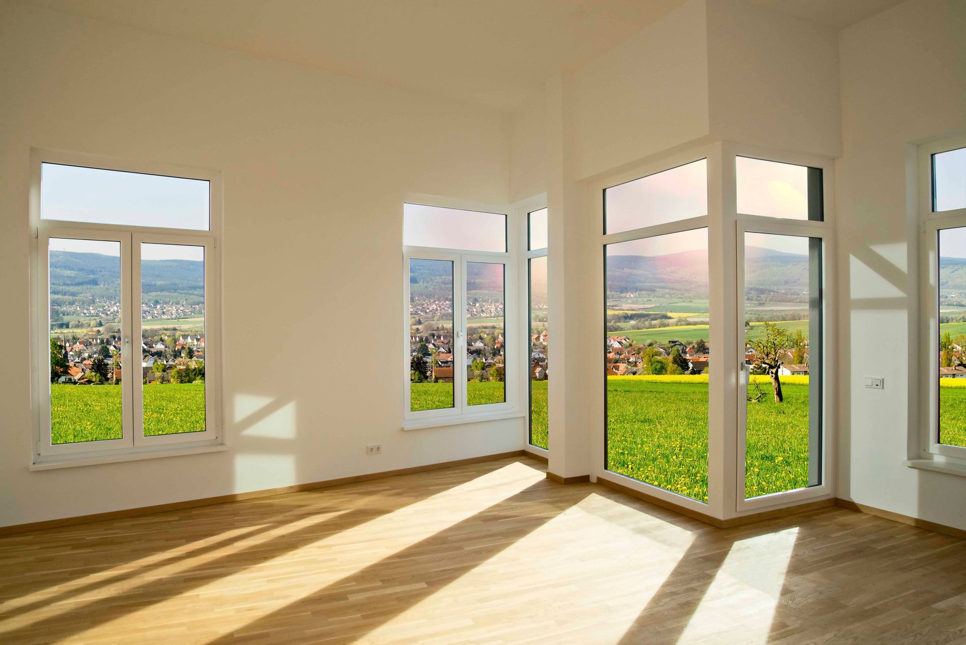 ein leerer Raum mit vielen Fenstern und einer Stadt im Hintergrund