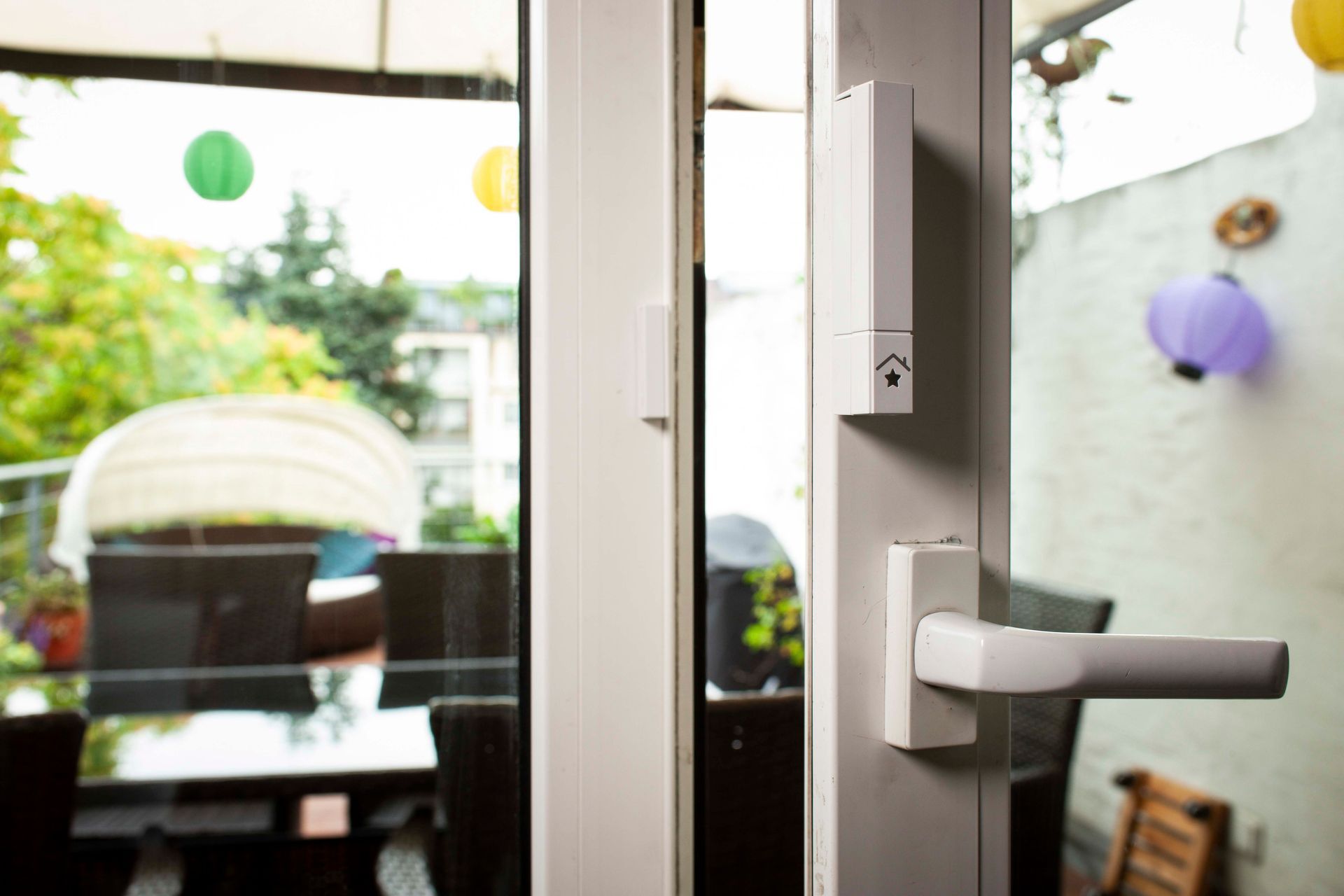 eine Glasschiebetür mit einem weißen Griff und einem Haussymbol darauf .