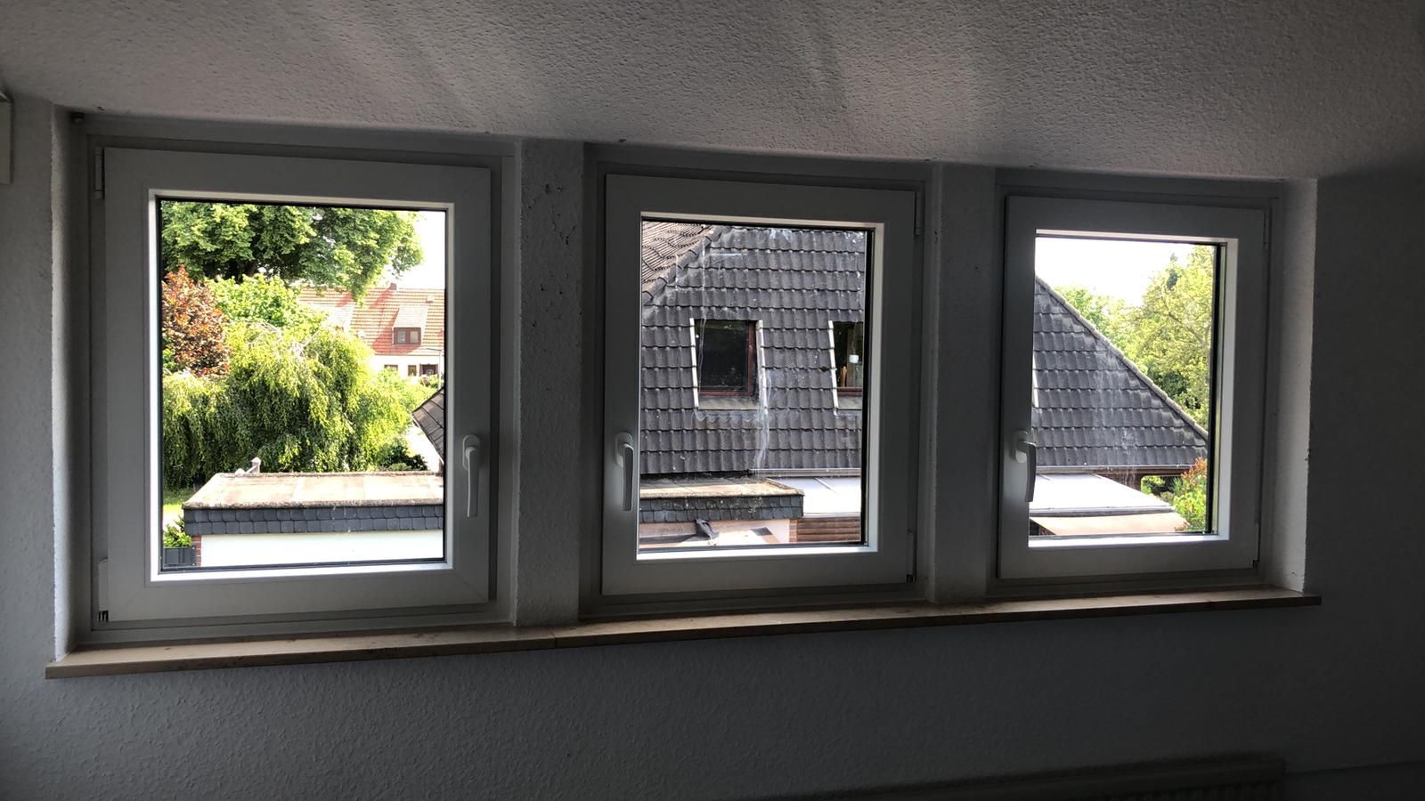 drei weiße Fenster mit Blick auf das Dach eines Hauses