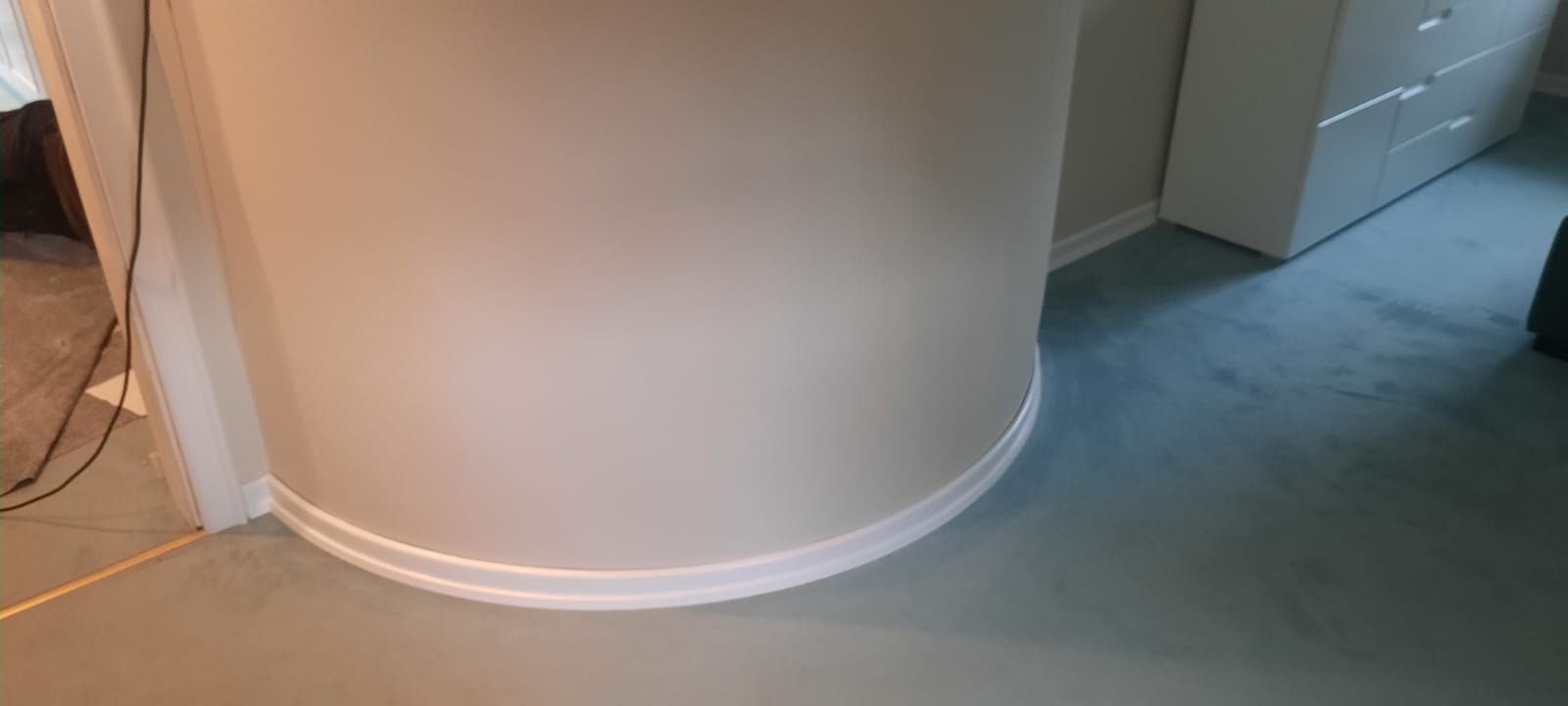 eine sehr schmal gebogene Wand in einem Raum