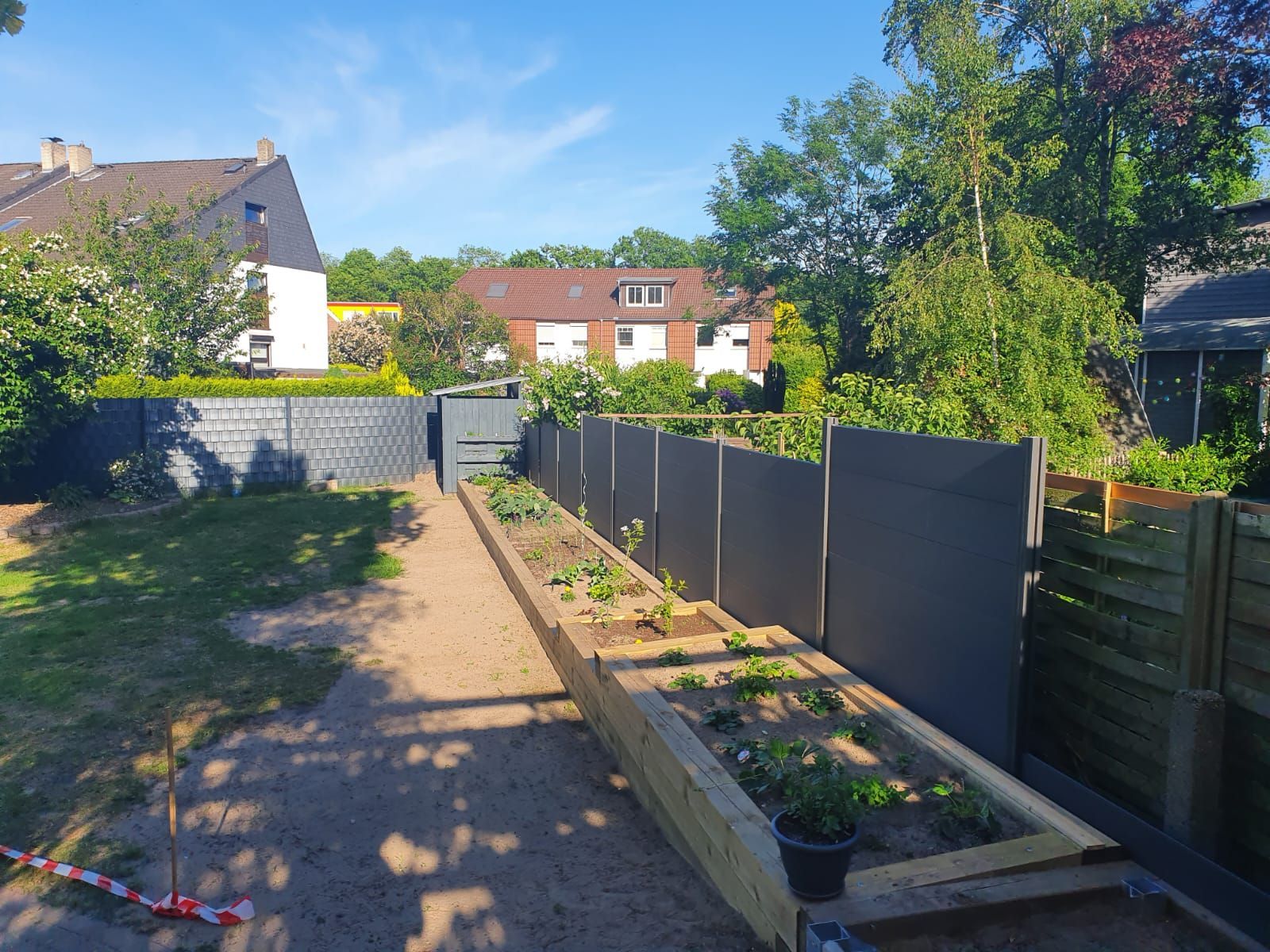 ein Garten mit vielen Pflanzen und einem Zaun