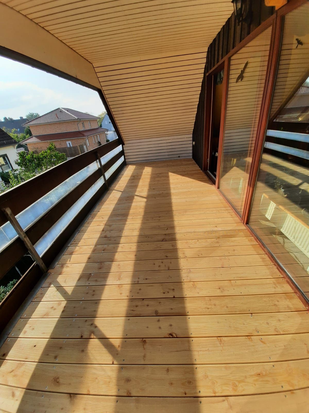 ein Holzdeck mit einer Schiebetür und einem Holzgeländer