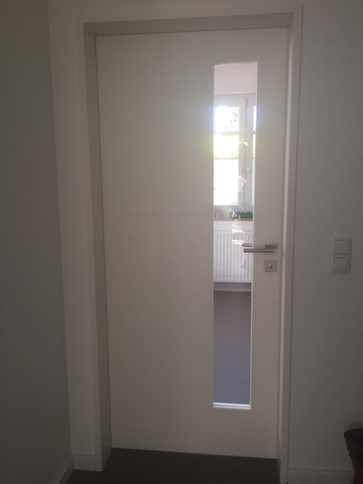 eine weiße Tür mit einem Fenster in der Mitte