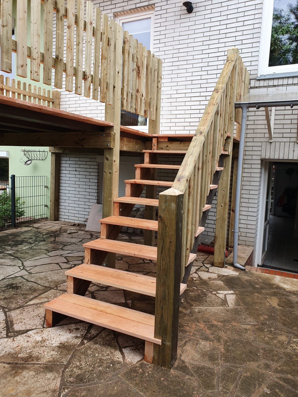 eine Holztreppe mit einem Holzzaun davor