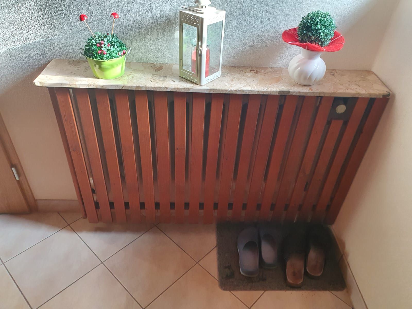 ein Holzheizkörper mit einer Lampe und einer Vase darauf