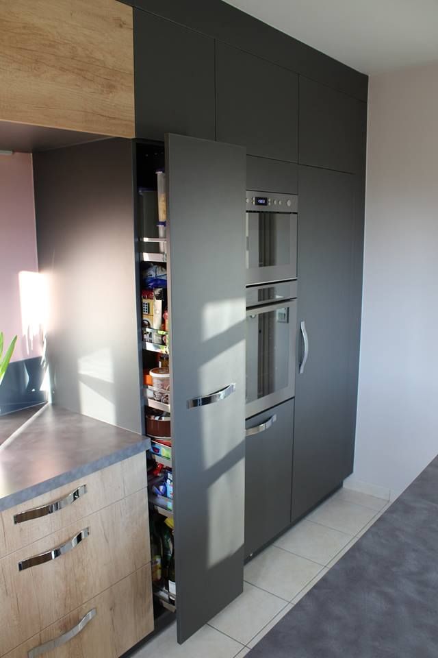 Démonstration d'ouverture d'un placard coulissant en avant avec plusieurs rangements, le meuble comprenant deux fours et un autre placard avec une porte battante