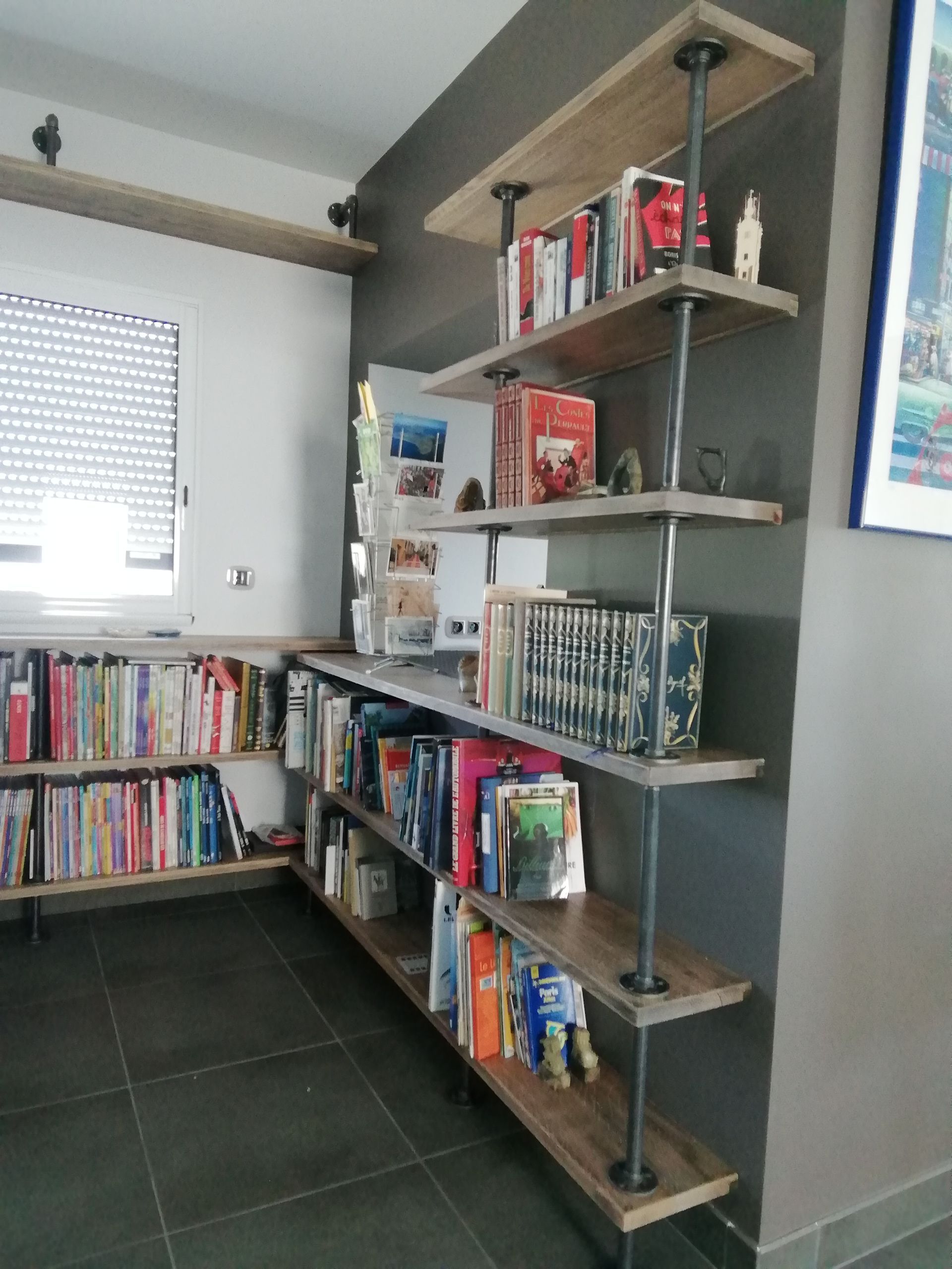 Bibliothèque sur mesure avec plusieurs niveaux et longeant deux murs, sans fond