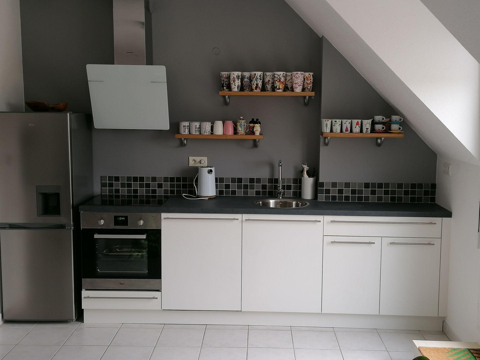 Cuisine sur mesure avec des façades de placard blanches et un plan de travail gris