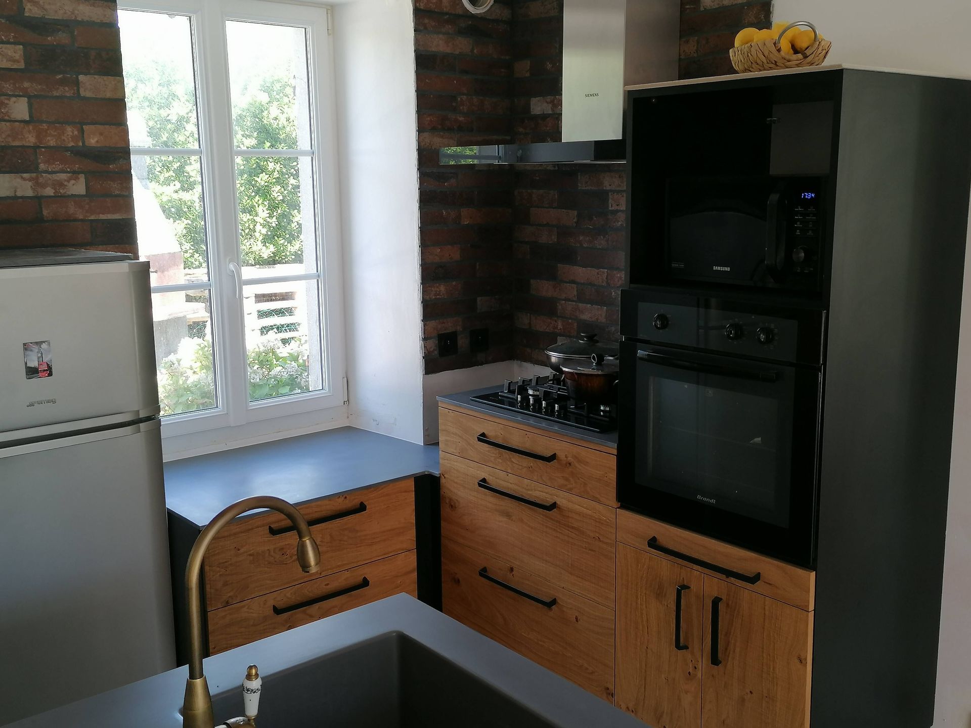 Cuisine sur mesure avec façade en chêne, querkus, corian gris et verrière