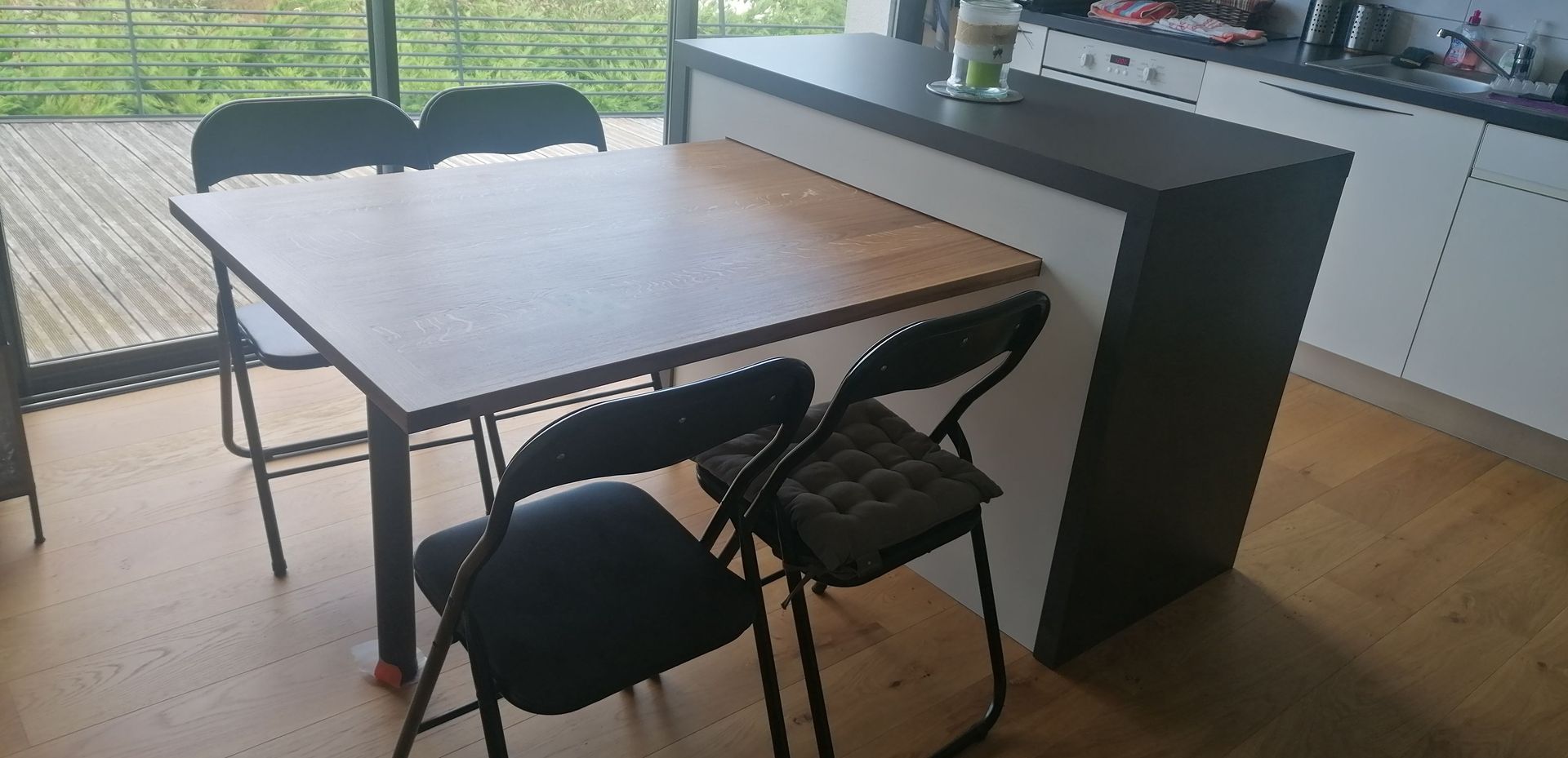 Cuisine sur mesure noire et blanche avec une table insérée dans un plan de travail