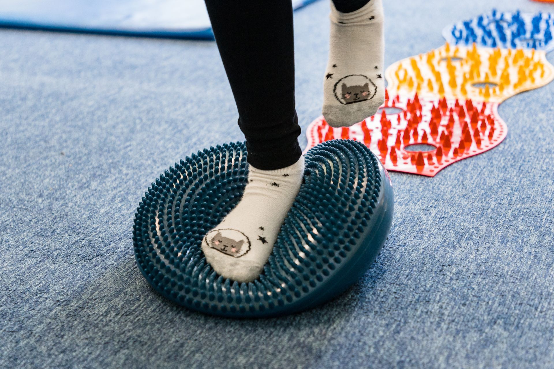 Eine Person hält sich das Knie und verdeutlicht so den Schmerz. Der Kniebereich leuchtet rot vor dem dunklen Hintergrund.