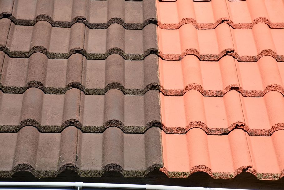 Gros plan sur un toit de tuiles brunes et en terre cuite, montrant un contraste de couleurs au centre.