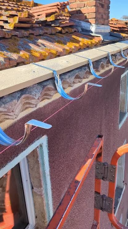 Travaux de préparation pour la pose de gouttières de toit.