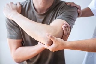 Hand hält Stift und tippt in den Taschenrechner