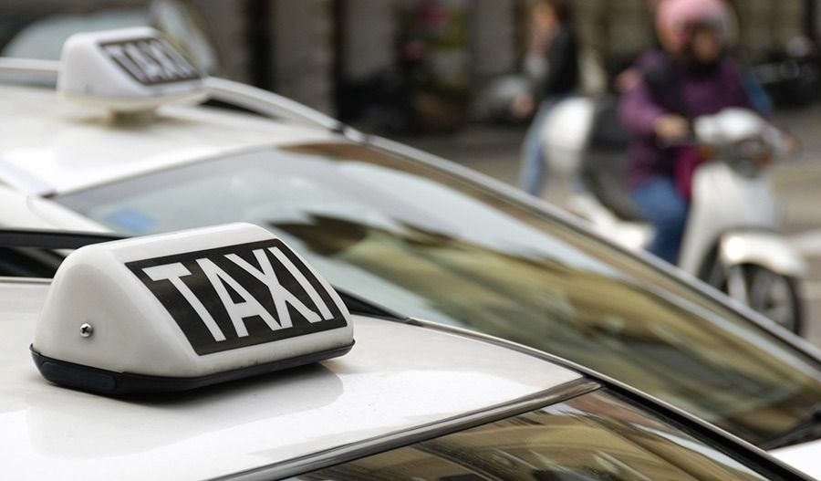 Dos taxis blancos con carteles iluminados de