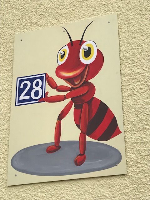 Eine Cartoon-Ameise hält ein Schild mit der Aufschrift 28