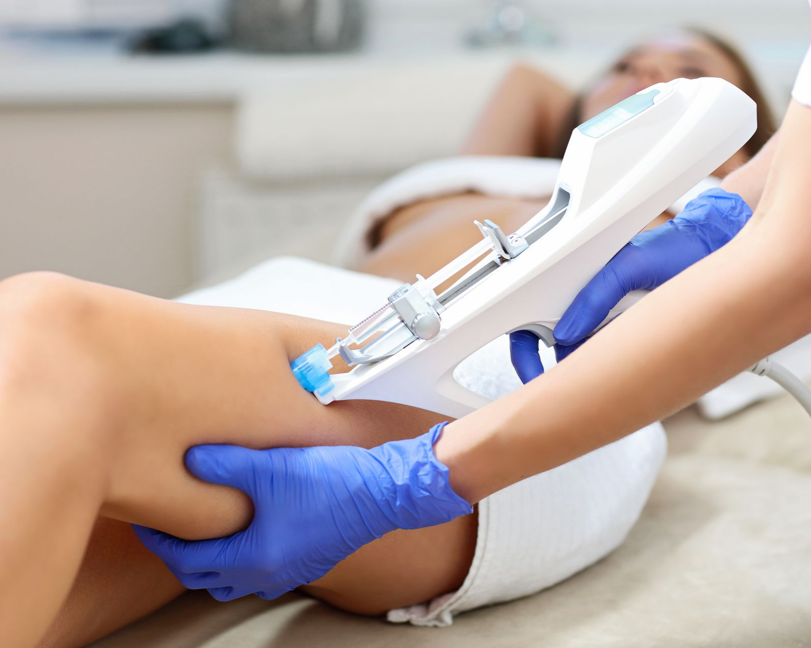 Une personne reçoit une injection médicale dans la jambe, pratiquée par une personne portant des gants.