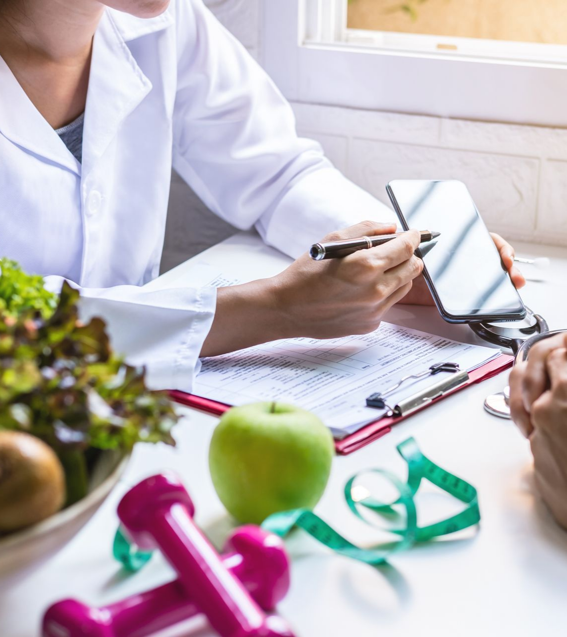 Une diététicienne montre son téléphone, affichant le plan de santé d'un patient.