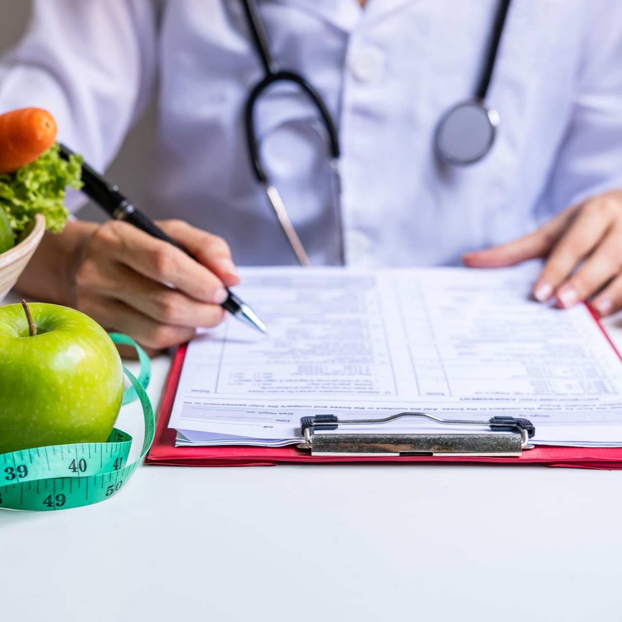 Une diététicienne prend des notes sur un bloc.