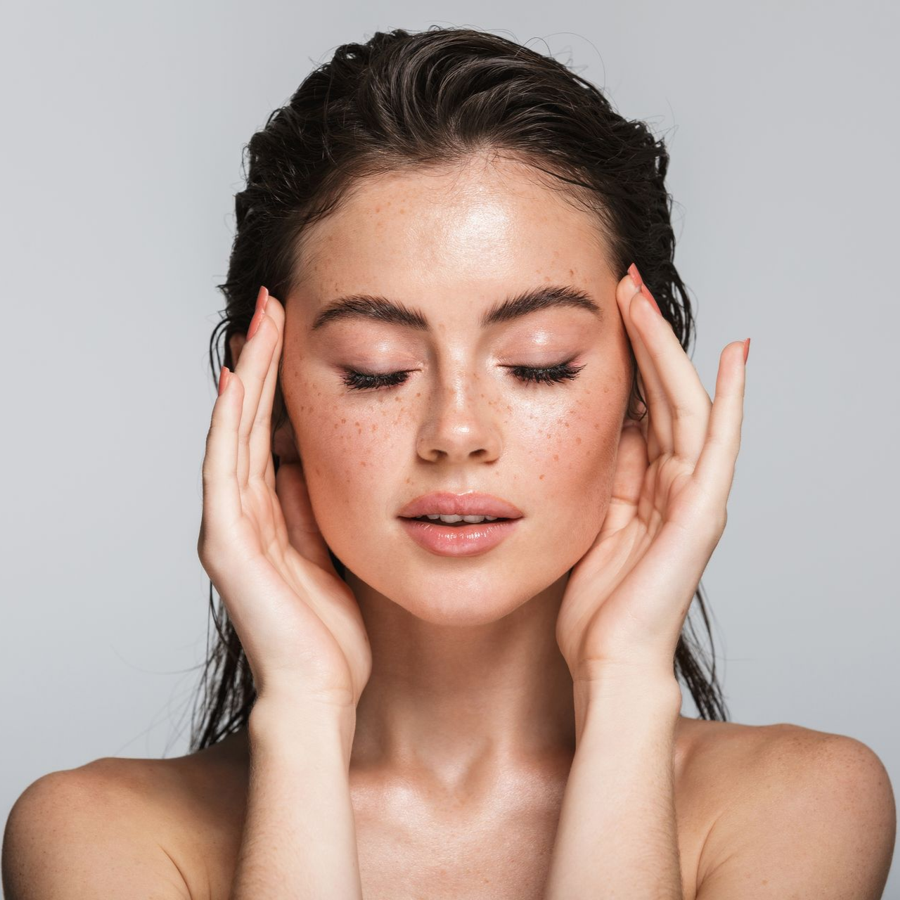 Femme aux yeux fermés, touchant doucement ses tempes.