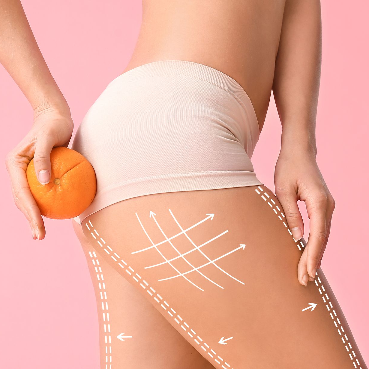 Une personne tenant une orange près d'une cuisse portant des flèches blanches.