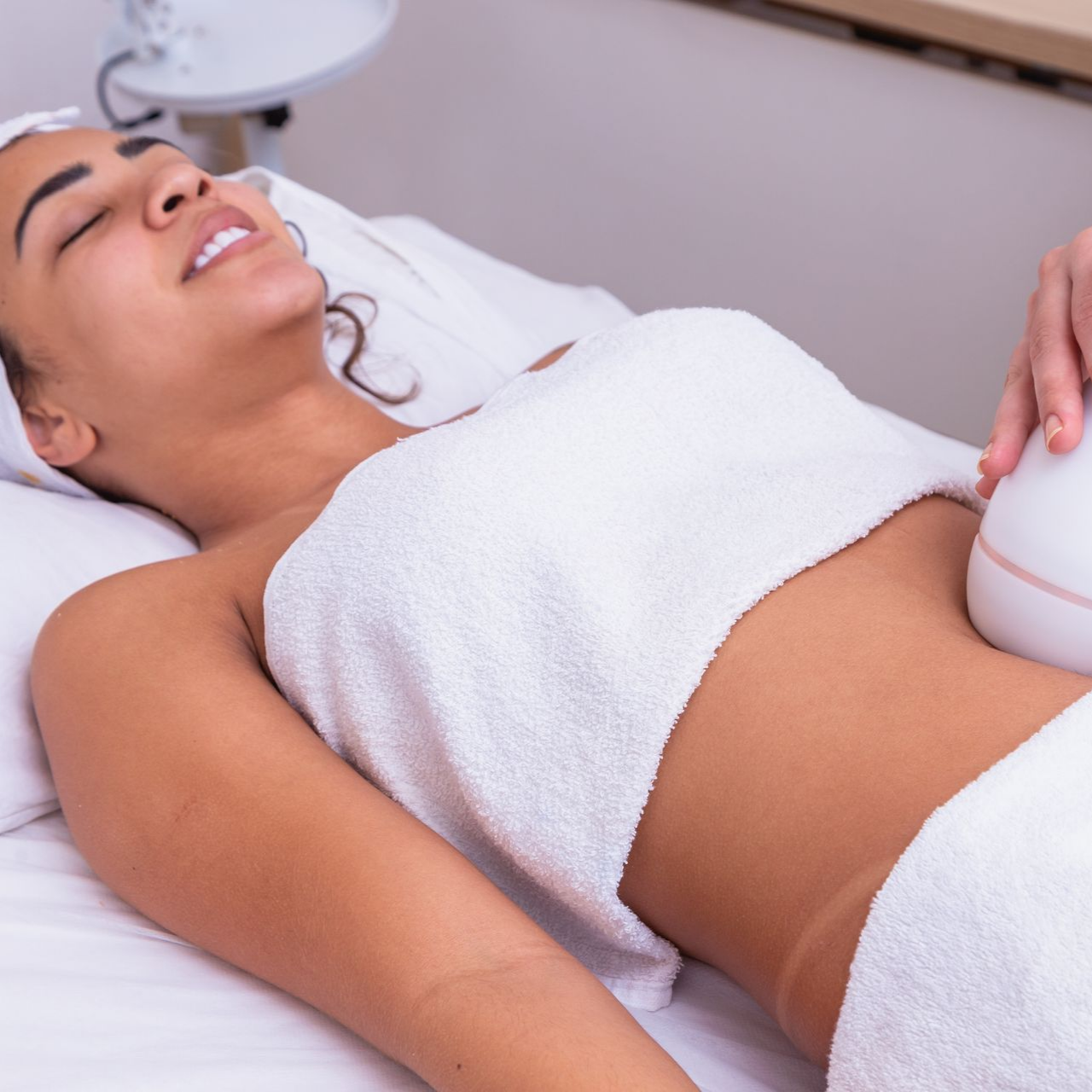 Une femme reçoit un soin du corps au niveau de l'abdomen.