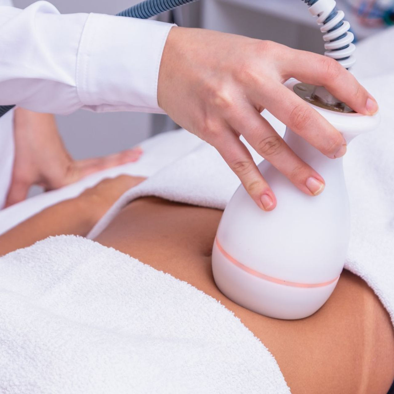 Une personne reçoit un traitement de remodelage corporel au niveau de l'abdomen.