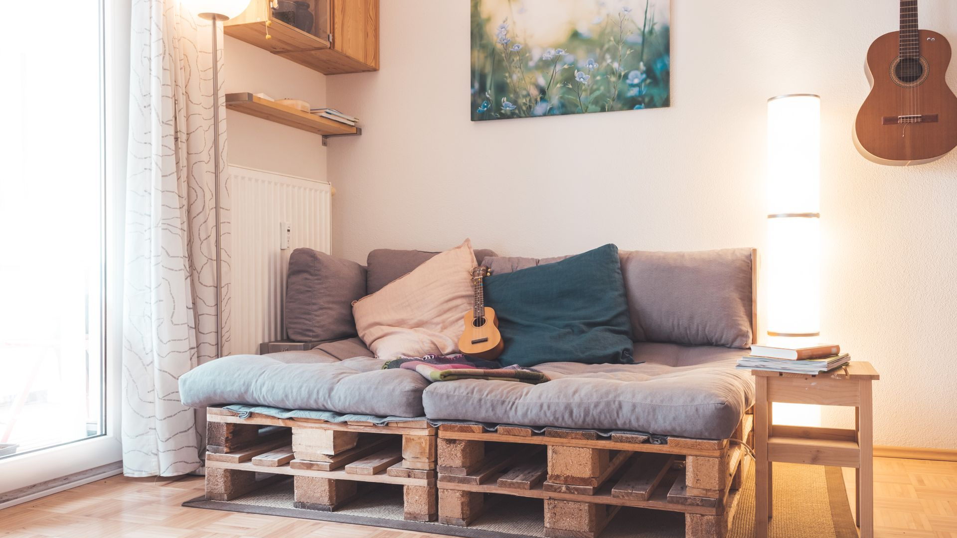 L'intérieur d'un salon décoré dans un style moderne avec un canapé, une guitare, un lampadaire